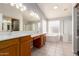 Large bathroom offers a tub, stand up shower, double sinks, and plentiful light at 2230 E Whitten St, Chandler, AZ 85225