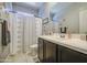 Bathroom features tile flooring, a dark wood vanity and white shower curtains at 23781 W Mohave St, Buckeye, AZ 85326