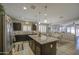 Open-concept kitchen with center island, dark cabinetry, stainless appliances, and bright lighting at 23781 W Mohave St, Buckeye, AZ 85326