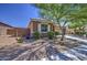 Side view of the house shows brick wall with colorful flowers with a well-manicured lawn at 23781 W Mohave St, Buckeye, AZ 85326