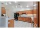 Bright kitchen featuring white tile floors, wood cabinetry, stainless appliances, and ample counter space at 238 W Myrna Ln, Tempe, AZ 85284