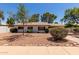 Lovely single-story home with desert landscaping, shrubs and mature trees in the front yard at 3021 E Windrose Dr, Phoenix, AZ 85032