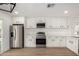 Well-lit kitchen with stainless steel appliances, quartz counters, and white cabinets at 3021 E Windrose Dr, Phoenix, AZ 85032