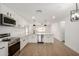 Open-concept kitchen with stainless appliances, white cabinets, and wood-look flooring at 3021 E Windrose Dr, Phoenix, AZ 85032