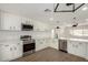 Modern white kitchen with stainless steel appliances, stylish hardware, and quartz countertops at 3021 E Windrose Dr, Phoenix, AZ 85032