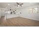 Open-concept living area with modern finishes, wood-look floors, ceiling fan and an open kitchen at 3021 E Windrose Dr, Phoenix, AZ 85032