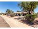 Well-maintained single-story home with desert landscaping, mature trees and a paved driveway at 3021 E Windrose Dr, Phoenix, AZ 85032