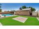 Well-maintained backyard features artificial turf, a paved patio area, and privacy fencing at 308 W Oraibi Dr, Phoenix, AZ 85027