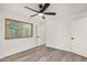 Neutral bedroom with wood-look flooring, a ceiling fan, and ample natural light at 308 W Oraibi Dr, Phoenix, AZ 85027