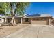 Exterior view of home with a two-car garage, and solar panels on the roof at 308 W Oraibi Dr, Phoenix, AZ 85027