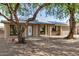 Home exterior with a well-maintained lawn, mature trees and solar panels at 308 W Oraibi Dr, Phoenix, AZ 85027