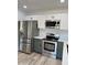 Modern kitchen with stainless steel appliances and gray and white cabinetry at 308 W Oraibi Dr, Phoenix, AZ 85027