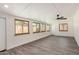 Bright and open living room with wood-look floors, multiple windows and modern ceiling fan at 308 W Oraibi Dr, Phoenix, AZ 85027