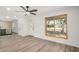 Open-concept living area with updated flooring, kitchen access, and a view of the outdoors at 308 W Oraibi Dr, Phoenix, AZ 85027