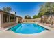 Sparkling pool surrounded by a concrete patio, with a grassy area and block wall for privacy at 308 W Oraibi Dr, Phoenix, AZ 85027