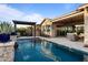 Backyard pool area features a covered patio, grill, and serene water features at 31210 N 122Nd Ln, Peoria, AZ 85383