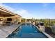 Landscaped backyard with a sparkling pool, stone waterfalls, and outdoor seating area at 31210 N 122Nd Ln, Peoria, AZ 85383