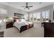 Spacious primary bedroom featuring a large bed, ceiling fan, and natural light from big windows at 31210 N 122Nd Ln, Peoria, AZ 85383