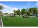 Lawn game area featuring Adirondack chairs, artificial turf, and string lights, great for outdoor entertaining at 31210 N 122Nd Ln, Peoria, AZ 85383