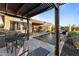 Covered outdoor patio boasts a dining area, grill, and pool with beautiful landscaping at 31210 N 122Nd Ln, Peoria, AZ 85383