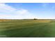 Expansive view of the perfectly manicured green golf course under a clear blue sky at 31210 N 122Nd Ln, Peoria, AZ 85383