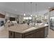 Open-concept kitchen with a large island, stone countertops, stainless steel appliances, and seamless access to living areas at 31210 N 122Nd Ln, Peoria, AZ 85383