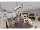 Open concept living space with modern lighting, a large dining table, and a stylish kitchen island at 31210 N 122Nd Ln, Peoria, AZ 85383