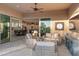 Inviting outdoor patio with comfortable seating, a ceiling fan, and an open view to the kitchen and dining area at 31210 N 122Nd Ln, Peoria, AZ 85383