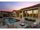 Beautiful backyard with a pool, fire pit and lush landscaping, ideal for outdoor enjoyment at 31210 N 122Nd Ln, Peoria, AZ 85383