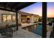 Inviting outdoor living space with a sparkling pool and covered patio at twilight at 31210 N 122Nd Ln, Peoria, AZ 85383