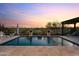 Stunning pool view with water features, desert landscaping, and beautiful sunset at 31210 N 122Nd Ln, Peoria, AZ 85383