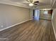 Open-concept living room featuring wood floors, tray ceiling with ceiling fan, and natural light at 3434 W Danbury Dr # A206, Phoenix, AZ 85053