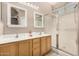 Bright bathroom featuring a double sink vanity with a glass-enclosed shower at 3685 N 141St Dr, Goodyear, AZ 85395