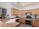 Functional kitchen features stainless steel appliances, tile countertops, and wood cabinets with ample storage at 3685 N 141St Dr, Goodyear, AZ 85395