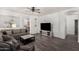 Living room with a large sectional, a ceiling fan, wood-look floors and open access to the kitchen at 3685 N 141St Dr, Goodyear, AZ 85395