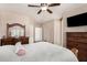 Bright main bedroom showcases plush bedding, tv, ceiling fan, and dresser with mirror at 3685 N 141St Dr, Goodyear, AZ 85395