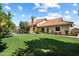 Expansive backyard featuring lush green grass, mature trees, pool, and a lovely rear home exterior at 4136 E Greenway Cir, Mesa, AZ 85205
