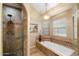 Luxurious bathroom features a soaking tub, elegant tilework, separate shower, and ample natural light at 4136 E Greenway Cir, Mesa, AZ 85205