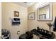 Stylish powder room with elegant fixtures, dark vanity, and decorative accents at 4136 E Greenway Cir, Mesa, AZ 85205