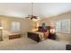 Well-lit main bedroom features a ceiling fan, plush carpet, window shutters, and stylish furniture at 4136 E Greenway Cir, Mesa, AZ 85205