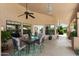 Relaxing covered patio with dining set, ceiling fan, and overhead lighting, perfect for outdoor gatherings at 4136 E Greenway Cir, Mesa, AZ 85205