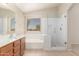 Bright bathroom featuring a glass-enclosed shower, soaking tub, and vanity with modern fixtures at 42196 W Chisholm Dr, Maricopa, AZ 85138