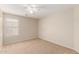 Neutral bedroom featuring carpet floors, ceiling fan, and large window at 42196 W Chisholm Dr, Maricopa, AZ 85138