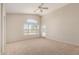 Bright and airy carpeted bedroom has ceiling fan, arched window and outside access at 42196 W Chisholm Dr, Maricopa, AZ 85138