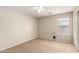 Neutral bedroom with carpet floors, ceiling fan and large window at 42196 W Chisholm Dr, Maricopa, AZ 85138