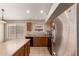 Kitchen with stainless steel appliances, wood cabinets and an island with a light-colored countertop at 42196 W Chisholm Dr, Maricopa, AZ 85138