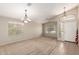Bright living room with neutral carpet, large windows, and a chandelier at 42196 W Chisholm Dr, Maricopa, AZ 85138