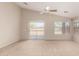 Open living room with neutral carpet, ceiling fan and natural light at 42196 W Chisholm Dr, Maricopa, AZ 85138