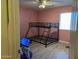 Bedroom with pink wall, bunk bed frame, and light wood flooring at 43418 W Wild Horse Trl, Maricopa, AZ 85138