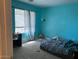 Bedroom with blue paint, window, carpet, poor conditions, and ceiling fan at 43418 W Wild Horse Trl, Maricopa, AZ 85138